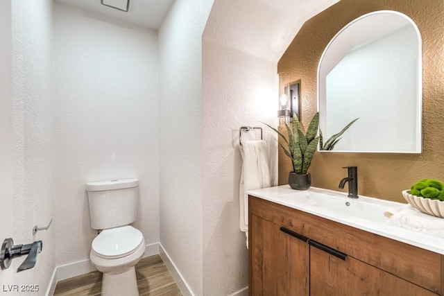 10009 Coral Sands Dr, Las Vegas, NV 89117 - half bath featuring wood finished floors, vanity, baseboards, toilet, and a textured wall