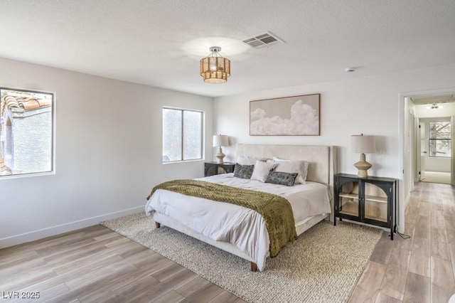 10009 Coral Sands Dr, Las Vegas, NV 89117 - bedroom featuring baseboards, a textured ceiling, light wood-style flooring, and visible vents