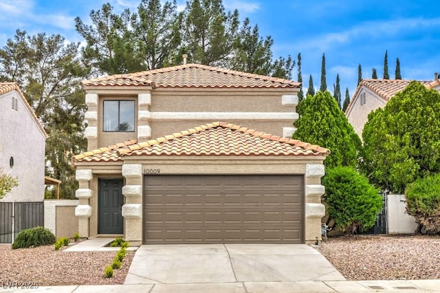 10009 Coral Sands Dr, Las Vegas, NV 89117 - mediterranean / spanish-style house with concrete driveway, an attached garage, a tile roof, and stucco siding