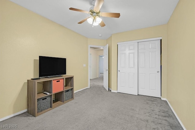 unfurnished bedroom with baseboards, ceiling fan, carpet, and a closet