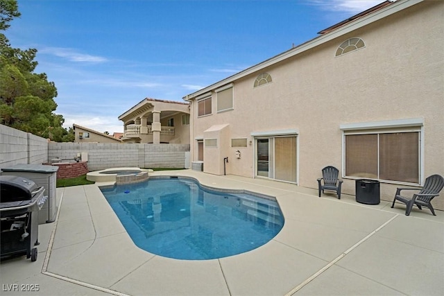 view of pool with a fenced backyard, a pool with connected hot tub, a grill, and a patio area
