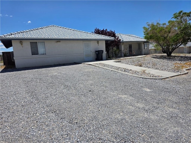 view of front of property featuring a tiled roof and stucco siding