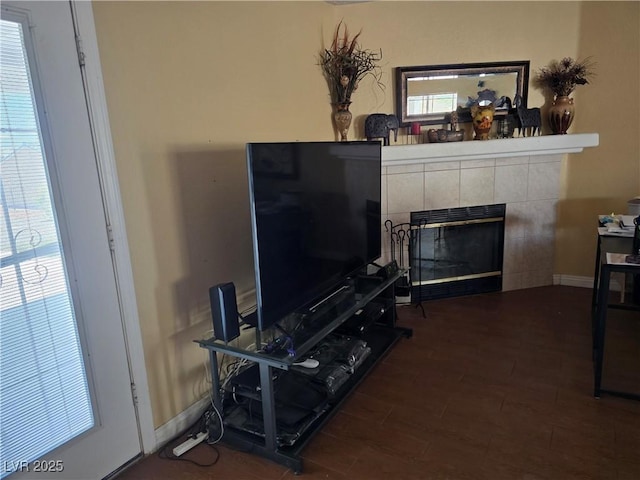 living area featuring dark wood finished floors, a healthy amount of sunlight, and a fireplace