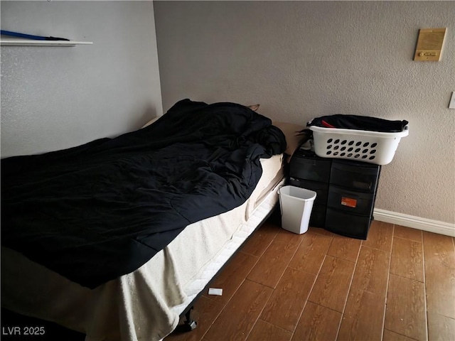 bedroom featuring baseboards and wood finished floors