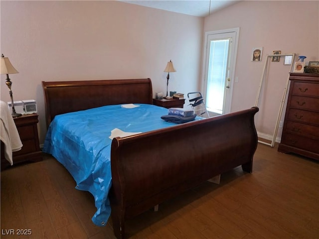 bedroom featuring baseboards, hardwood / wood-style floors, and lofted ceiling