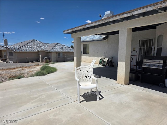 view of patio with fence and a grill