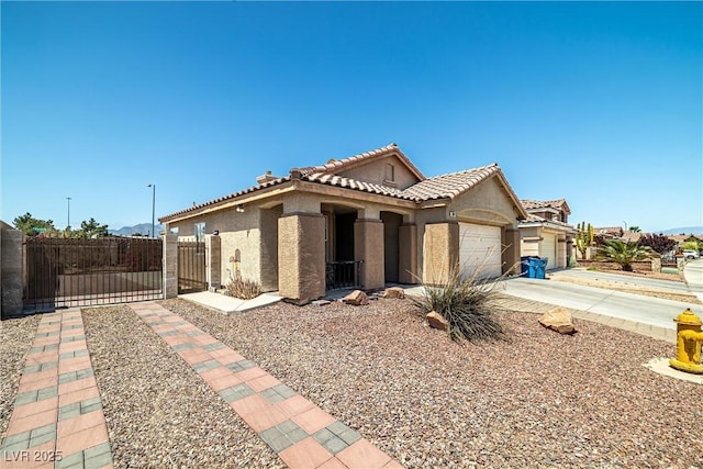 view of front of house featuring fence, an attached garage, stucco siding, a gate, and a tiled roof