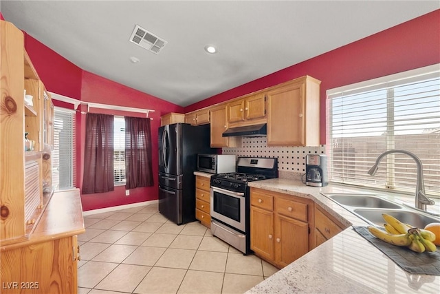 kitchen featuring visible vents, stainless steel appliances, a sink, lofted ceiling, and under cabinet range hood
