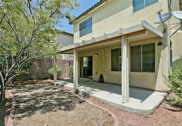 back of property with fence, a patio, and stucco siding