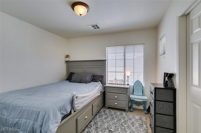 bedroom with light colored carpet, visible vents, and multiple windows