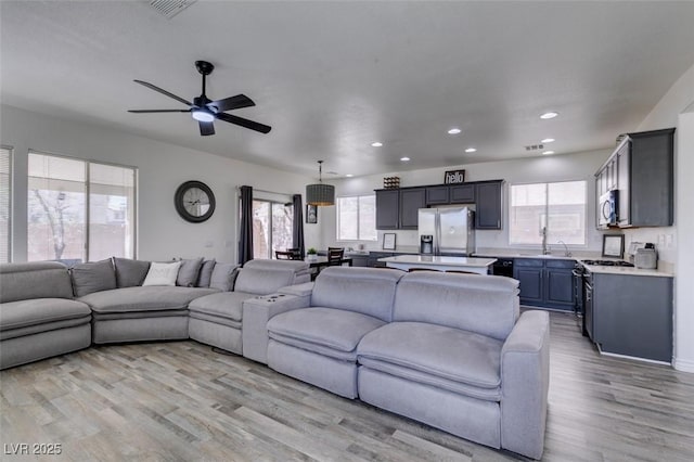 living area featuring recessed lighting, ceiling fan, visible vents, and light wood finished floors
