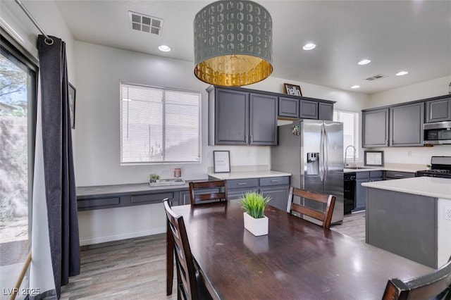kitchen featuring light countertops, stainless steel appliances, light wood-type flooring, and visible vents