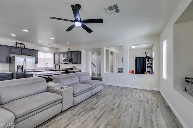 living room with visible vents, baseboards, ceiling fan, recessed lighting, and light wood finished floors