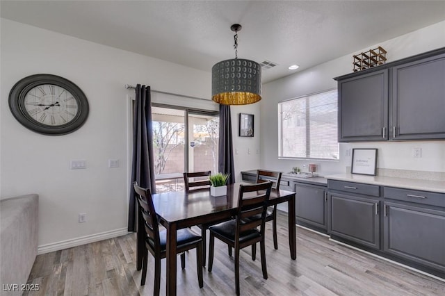 dining area with baseboards, plenty of natural light, light wood-style flooring, and visible vents