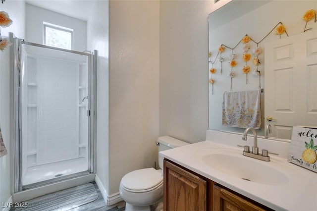 bathroom featuring vanity, a stall shower, and toilet