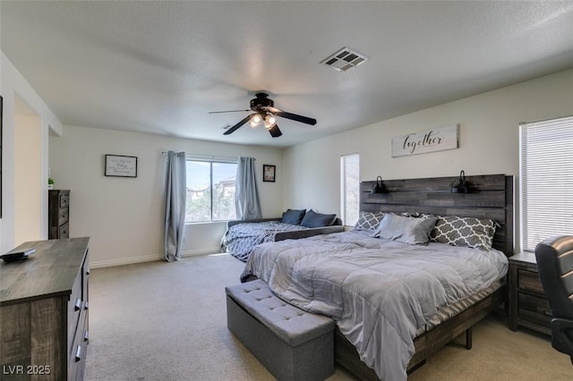 bedroom featuring a ceiling fan, baseboards, light colored carpet, and visible vents