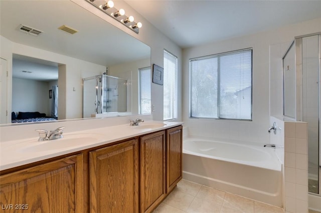 ensuite bathroom featuring visible vents, connected bathroom, tile patterned floors, a sink, and a stall shower