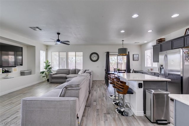 living room with a healthy amount of sunlight, light wood finished floors, and visible vents