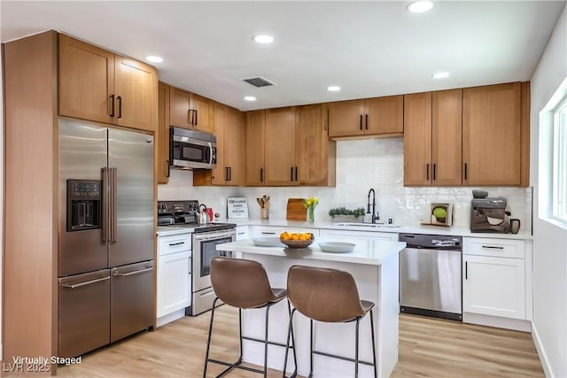 kitchen featuring a sink, light wood-style floors, light countertops, stainless steel appliances, and visible vents