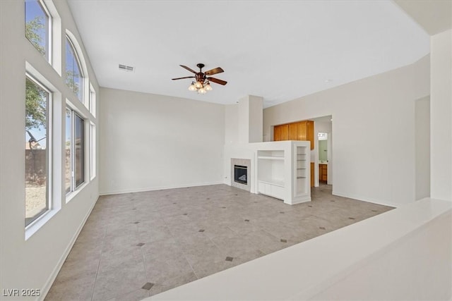 1326 Winter Solstice Ave, Henderson, NV 89014 - unfurnished living room featuring visible vents, a fireplace, baseboards, tile patterned floors, and a ceiling fan