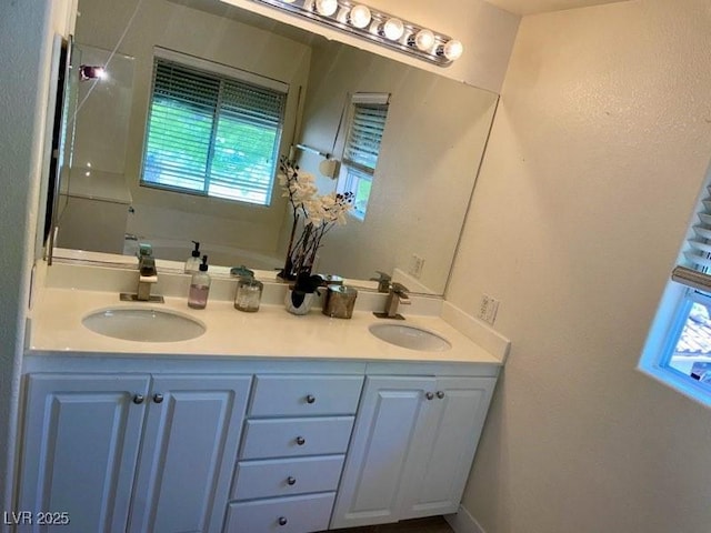 full bathroom with double vanity and a sink