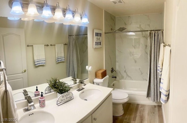 full bathroom featuring toilet, shower / bath combo, a sink, and wood finished floors