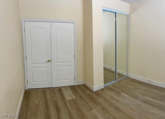 unfurnished bedroom with baseboards and wood finished floors