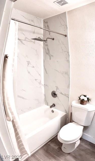 bathroom with toilet, shower / bath combo, visible vents, and wood finished floors