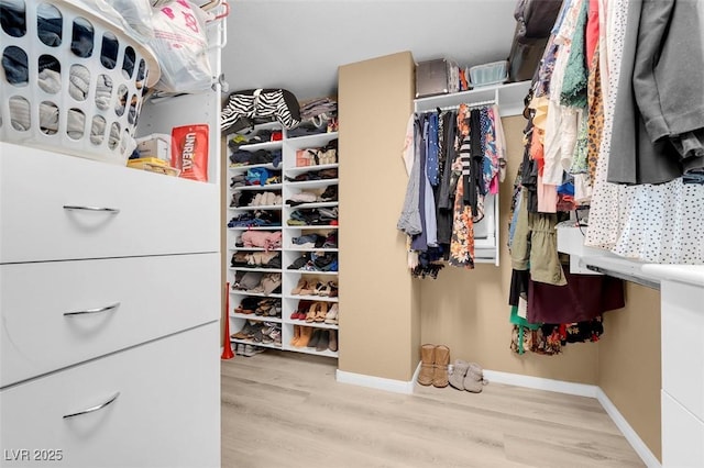 walk in closet with wood finished floors