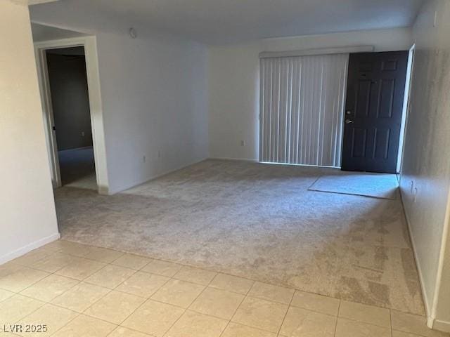 empty room with baseboards and light carpet