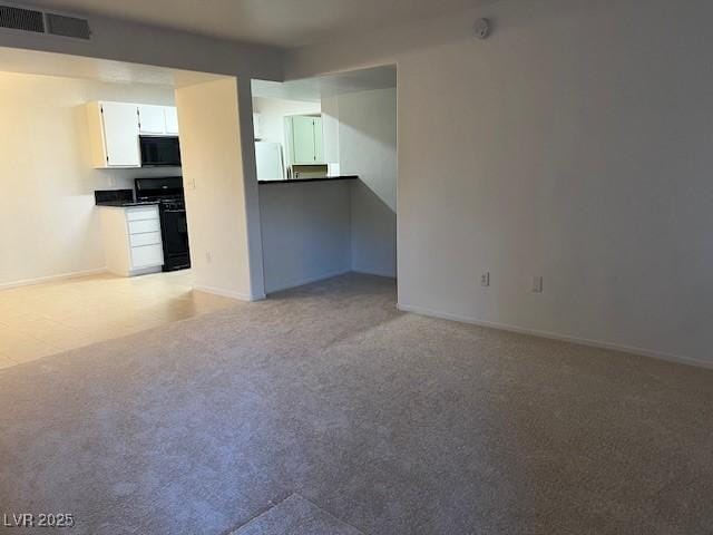 unfurnished living room featuring carpet floors, baseboards, and visible vents