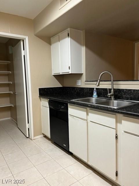 kitchen with a sink, light tile patterned floors, white cabinetry, and dishwasher