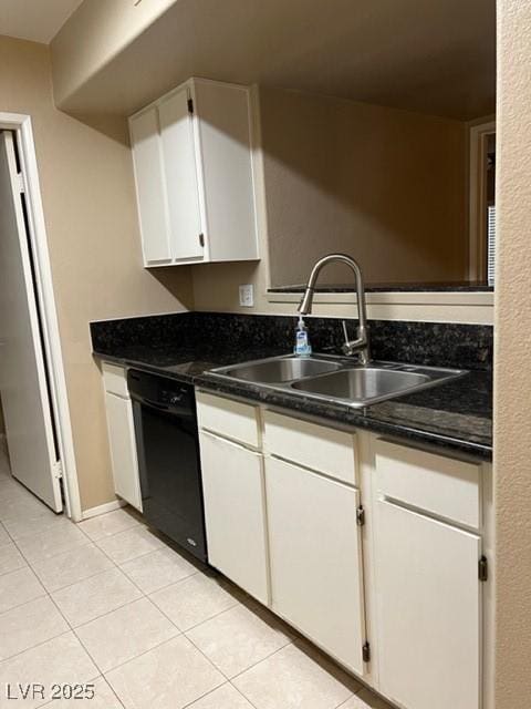 kitchen with dark countertops, dishwasher, a sink, white cabinets, and light tile patterned flooring