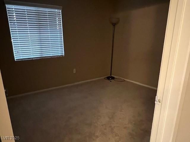 carpeted empty room featuring baseboards