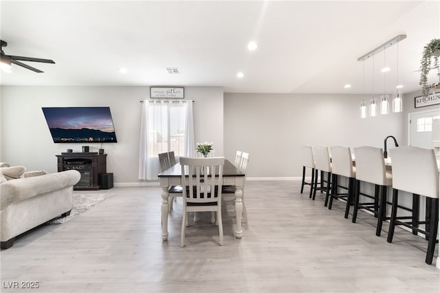 dining space featuring baseboards, ceiling fan, light wood finished floors, and recessed lighting