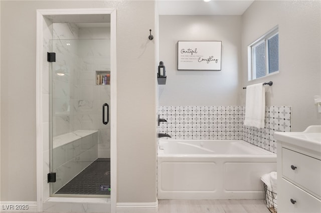 bathroom featuring vanity, a garden tub, and a stall shower