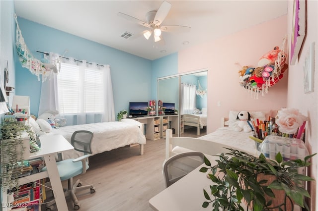 bedroom featuring ceiling fan, a closet, wood finished floors, and visible vents