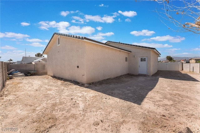 view of property exterior with a fenced backyard and stucco siding