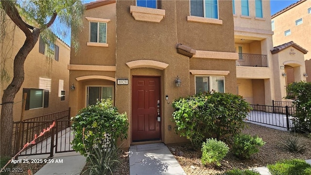 doorway to property with stucco siding and fence