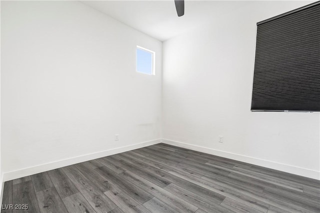 spare room featuring baseboards, a ceiling fan, and dark wood-style floors