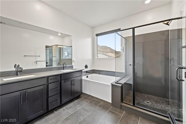 bathroom featuring a sink, a garden tub, a stall shower, and double vanity