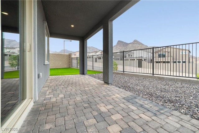 view of patio with a fenced backyard, a mountain view, and a residential view