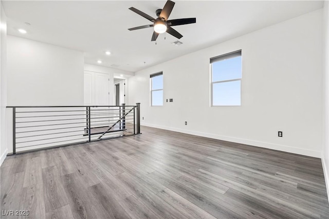 unfurnished room featuring visible vents, baseboards, ceiling fan, and wood finished floors