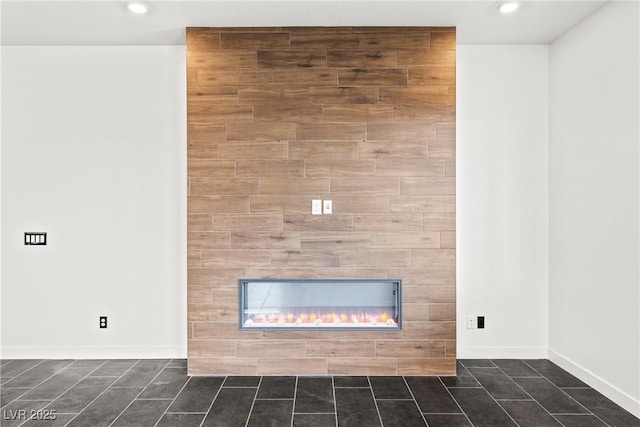 interior details featuring baseboards, recessed lighting, and a tile fireplace