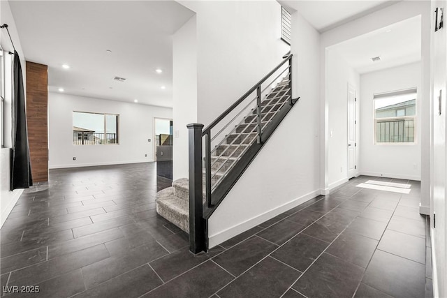 staircase with baseboards, recessed lighting, and a wealth of natural light