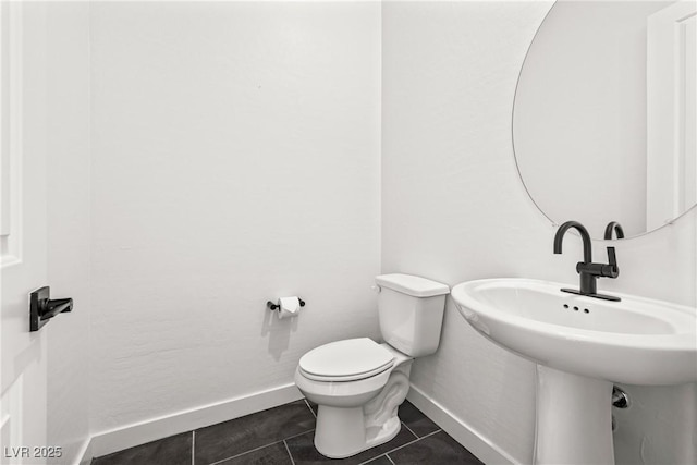 bathroom with baseboards, a sink, tile patterned floors, and toilet