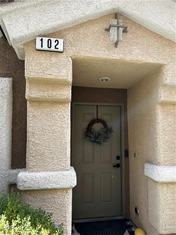 doorway to property featuring stucco siding