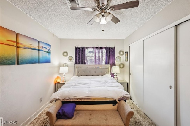 bedroom with a textured ceiling, baseboards, carpet, and a closet