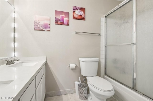 full bath with double vanity, tile patterned flooring, a sink, baseboards, and toilet