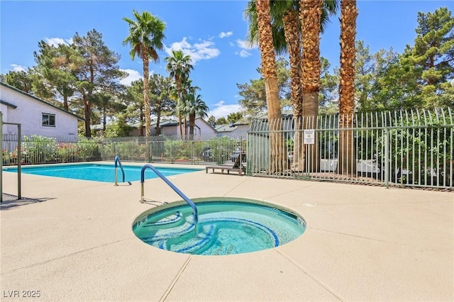 pool with a patio, a hot tub, and fence